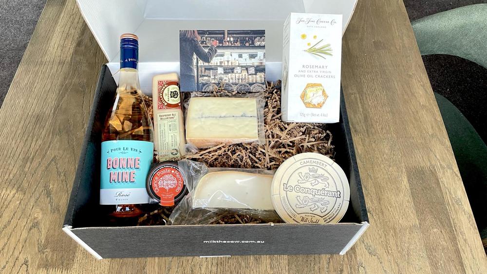 Box containing wine, cheeses and quince