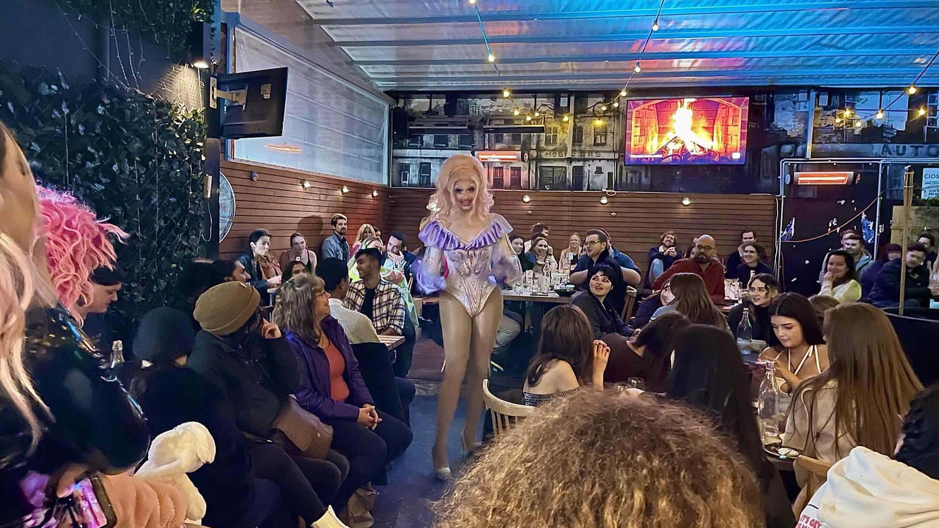 A drag queen will elaborate blonde wig performs to the crowd